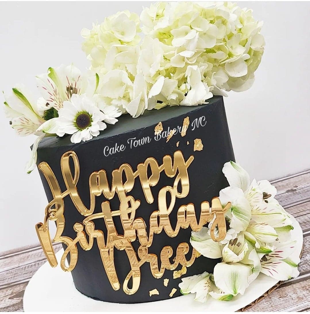 Black and white birthday cake with fresh flowers